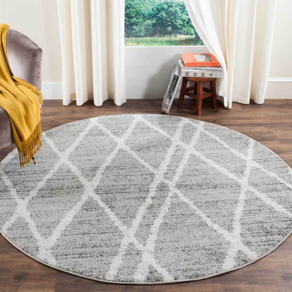 Round ivory and silver rug brings soft texture and sweeping geometric lines to a living space
