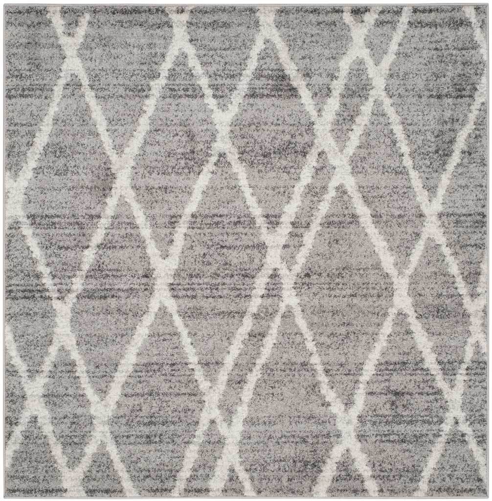A square silver-gray rug features overlapping ivory diamonds and a softly mottled texture.