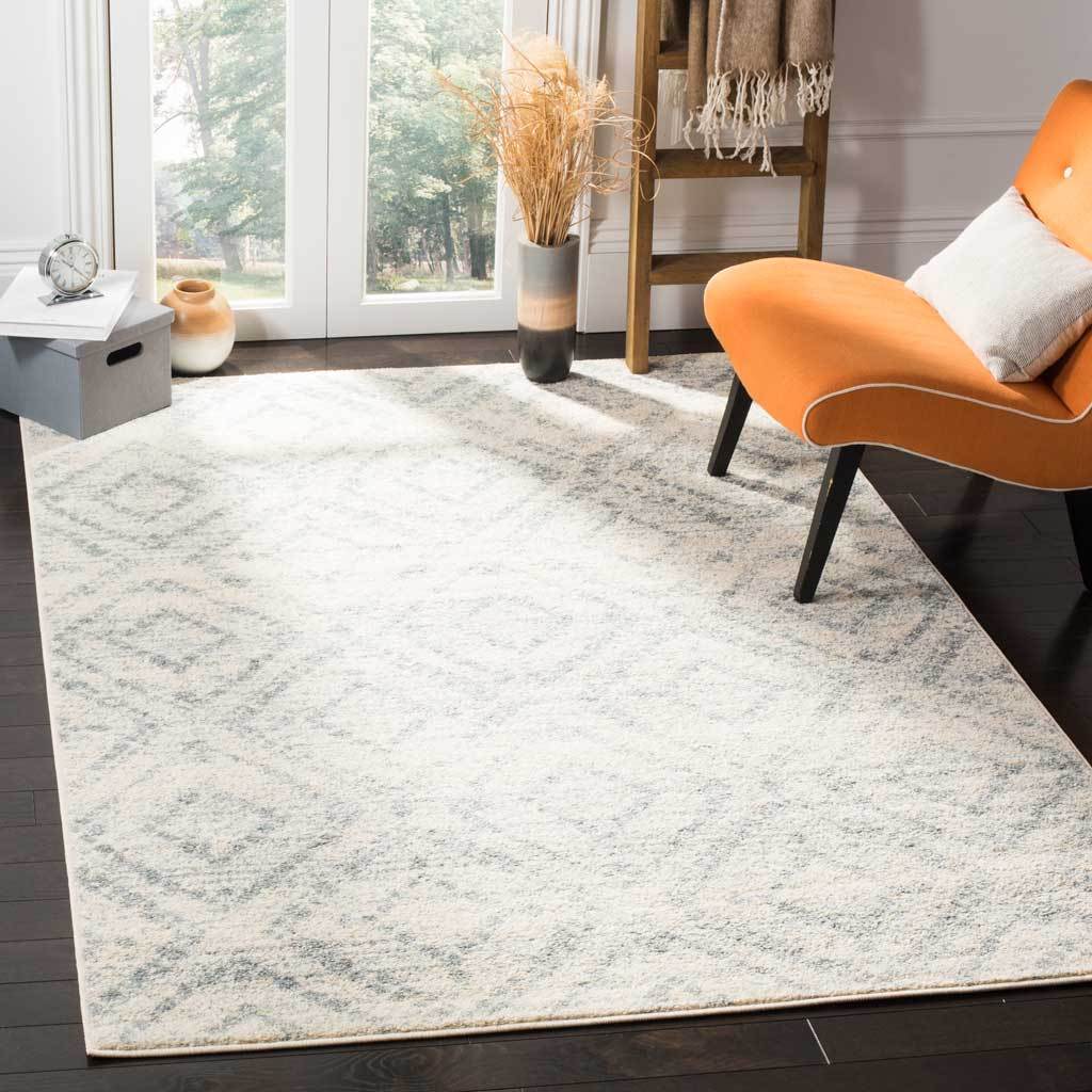 An ivory and light blue geometric rug adds soft texture beneath modern furnishings