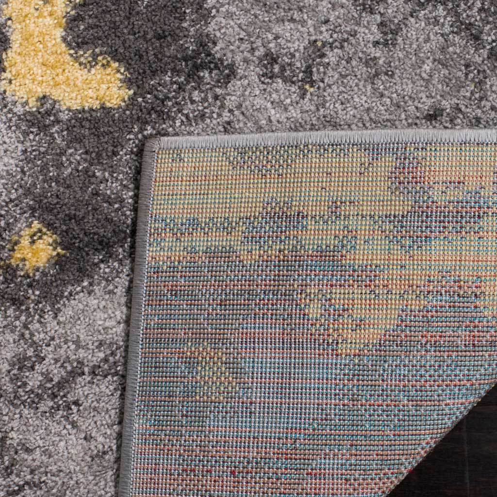 A woven backing adds structure beneath the rug's textured gray and yellow surface.