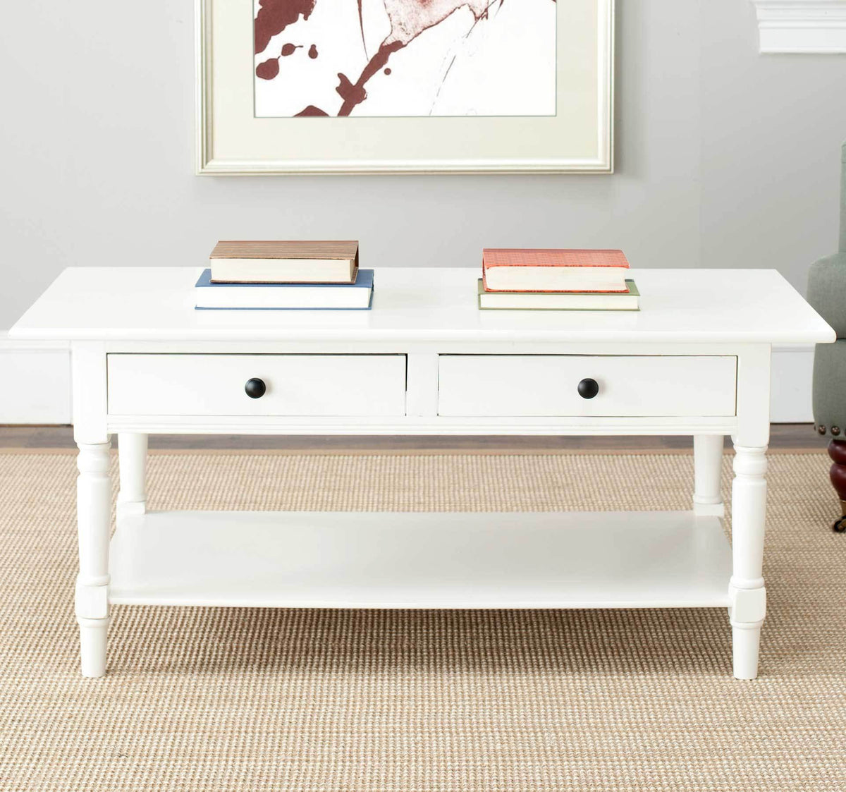 A light cream finish and dark drawer knobs bring vintage charm to this coffee table