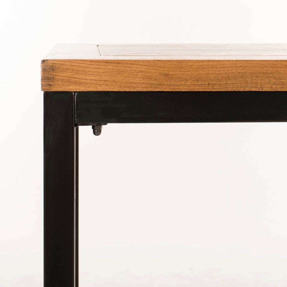Warm wood grain meets a dark iron frame at the clean-lined tabletop corner