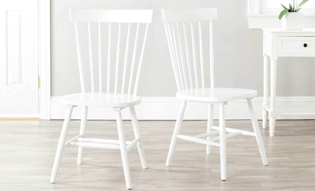 Two white spindle-back chairs brighten a dining room with shapely seats and splayed legs.