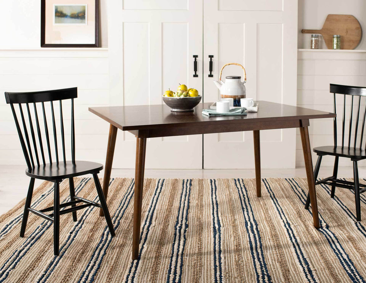 Black spindle-back dining chairs bring timeless style to a table and striped rug.