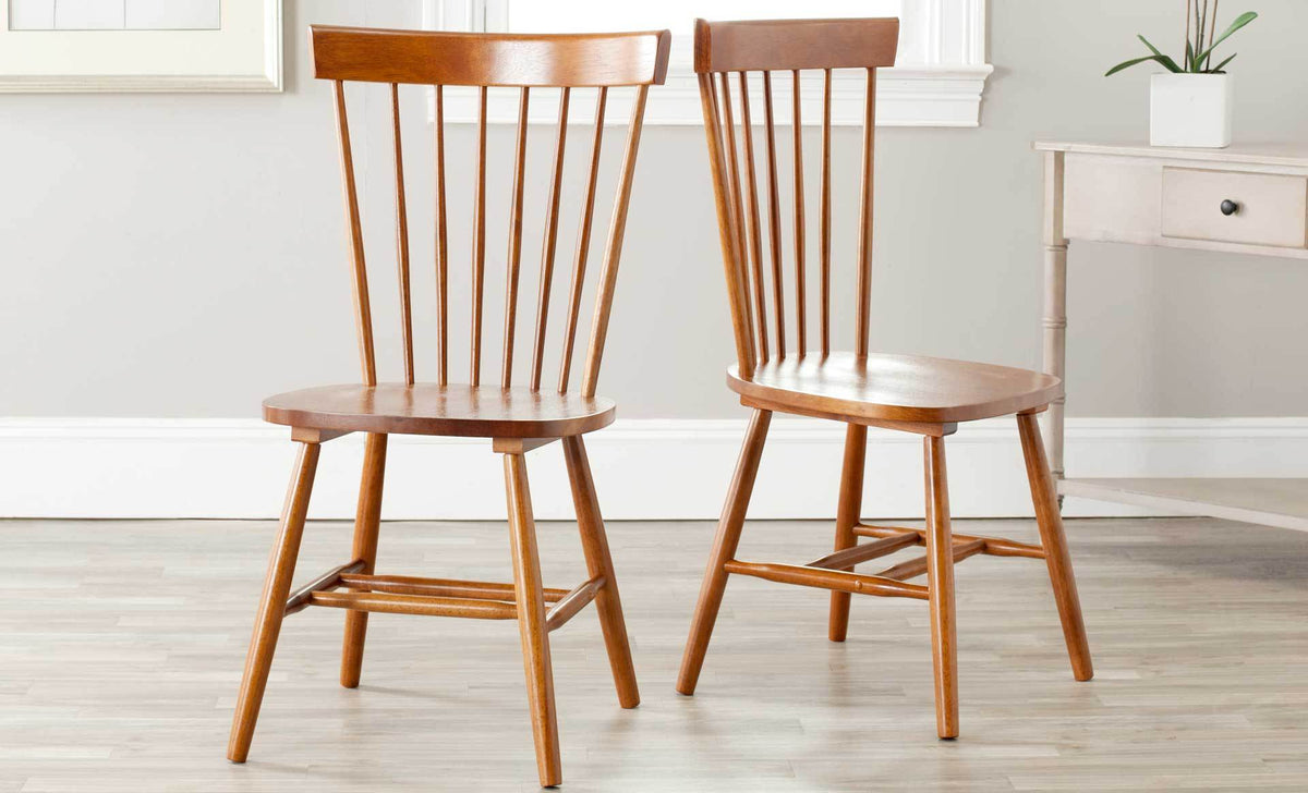 A pair of brown spindle-back chairs warms a bright room with wood seats and splayed legs.