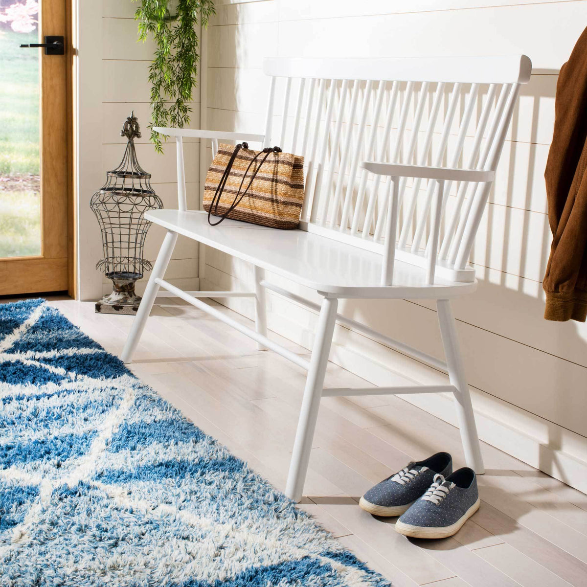 White spindle-back seating brings open arms and angled legs to a bright entryway.