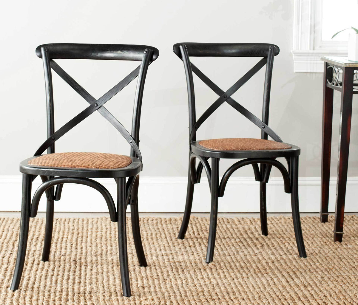 A pair of black oak chairs brings woven rattan texture and classic X-backs to a dining space
