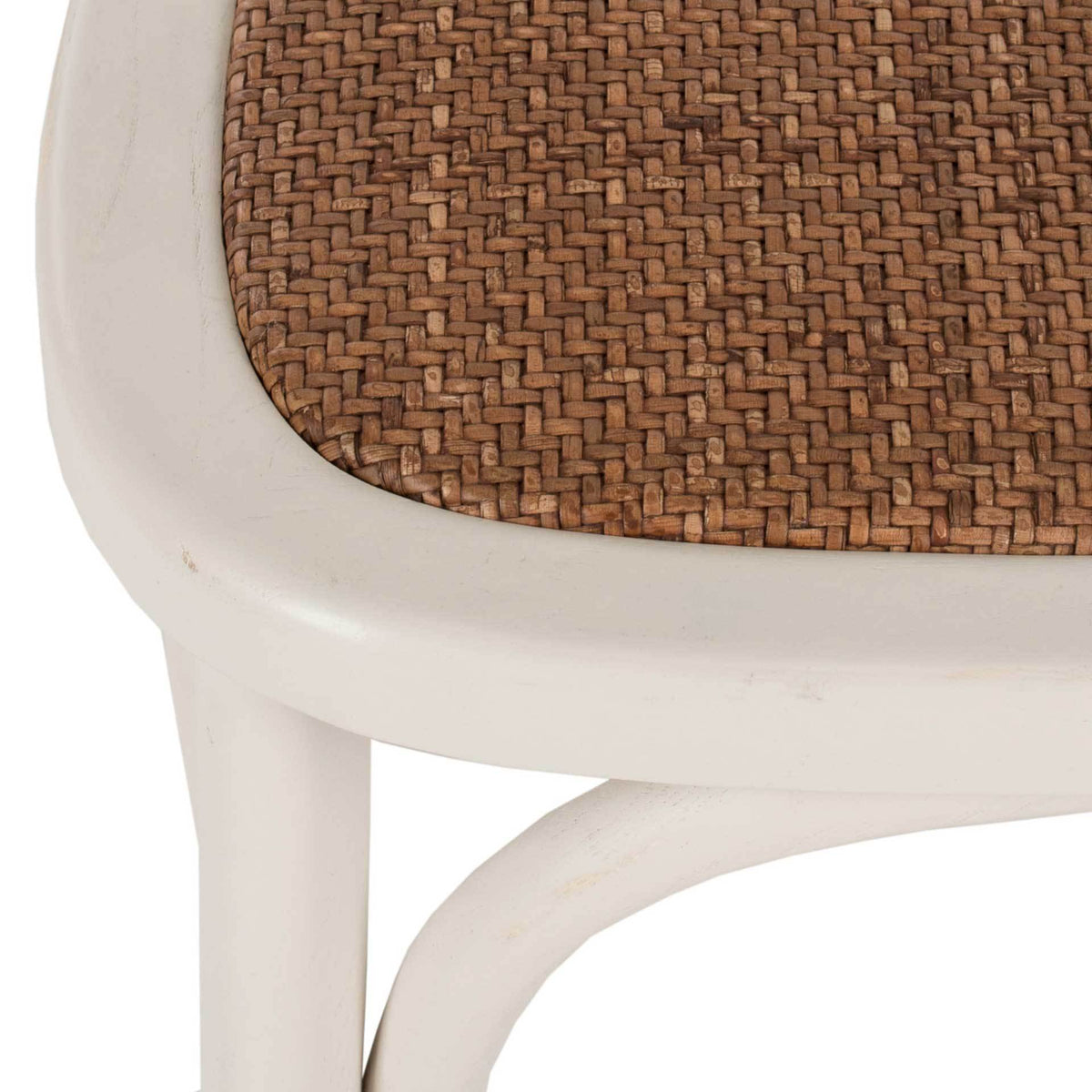 Woven rattan seat and softly distressed ivory frame meet above a gracefully curved brace.