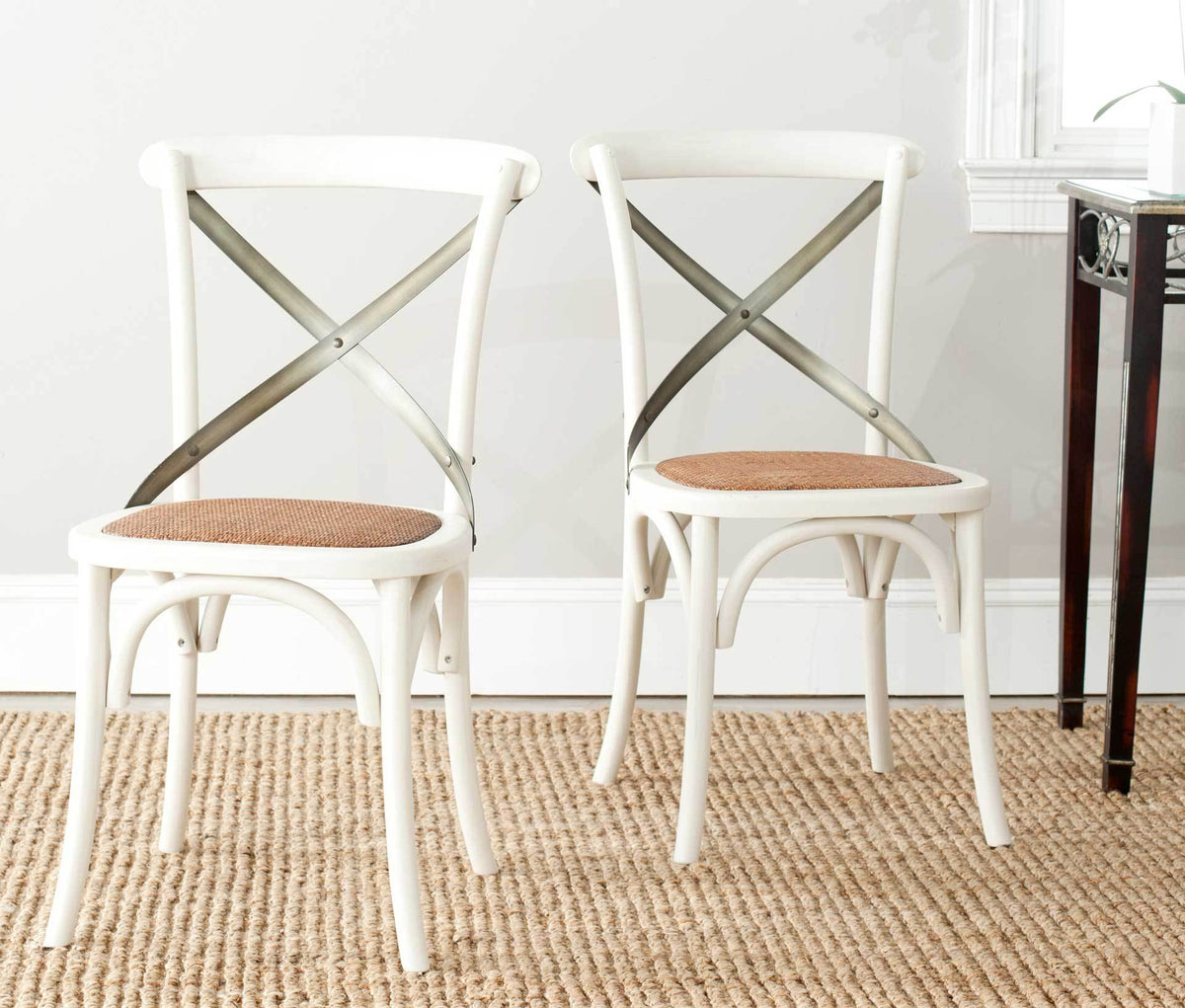 Two antique white X-back chairs add airy farmhouse style with woven rattan seats and arched braces.