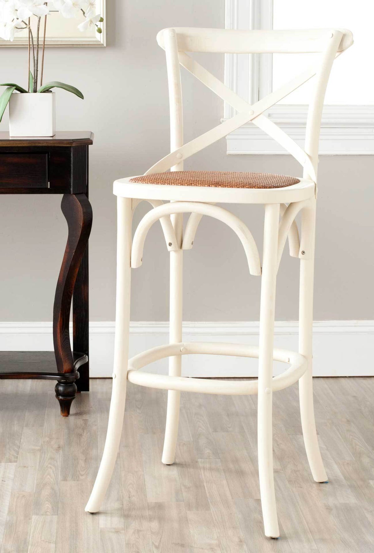 Antique white wood and woven rattan lend this tall X-back stool easy farmhouse appeal