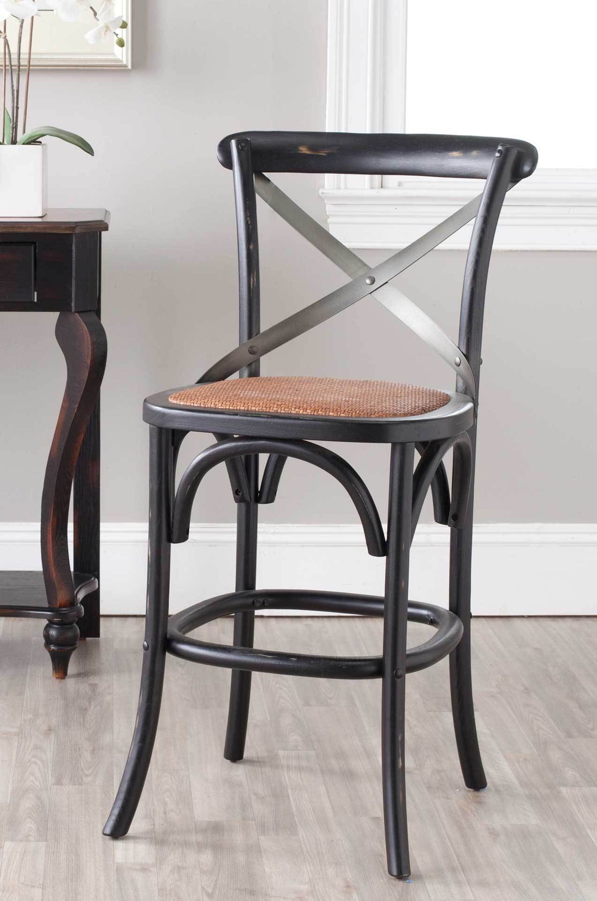 Cafe-inspired black counter stool pairs a woven seat with graceful curves and a round foot rail