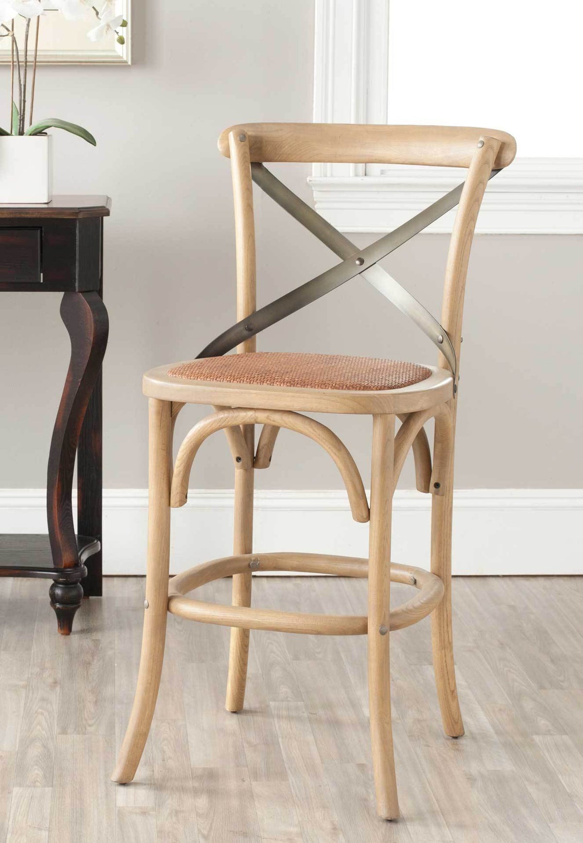 Natural-toned counter stool pairs a textured rattan seat with dark metal cross-back detailing