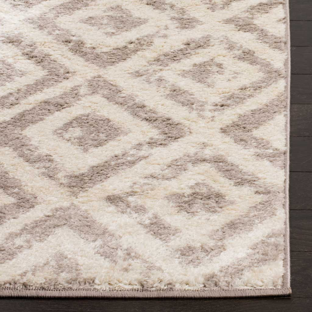 Soft ivory pile frames muted mauve diamonds above a neatly bound edge