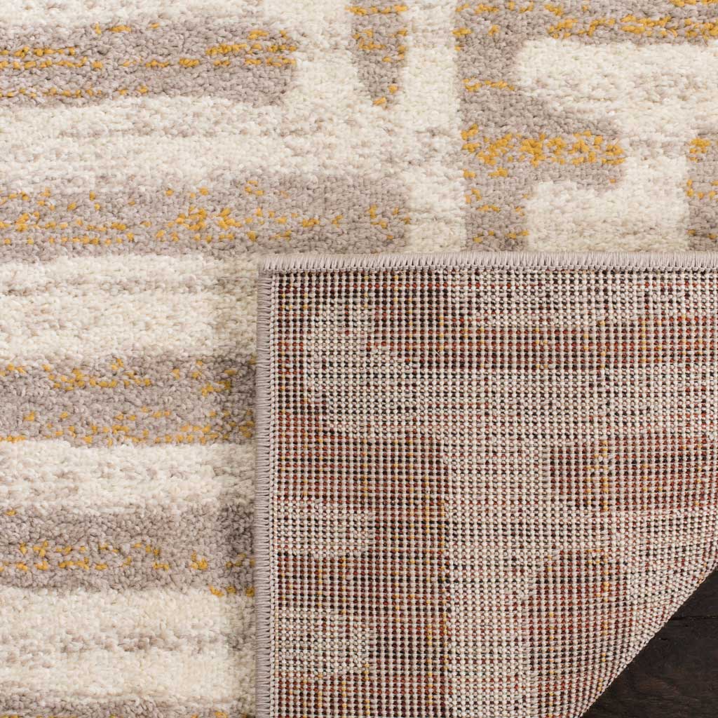 A tightly woven backing reinforces the ivory rug's soft mauve patterned pile.