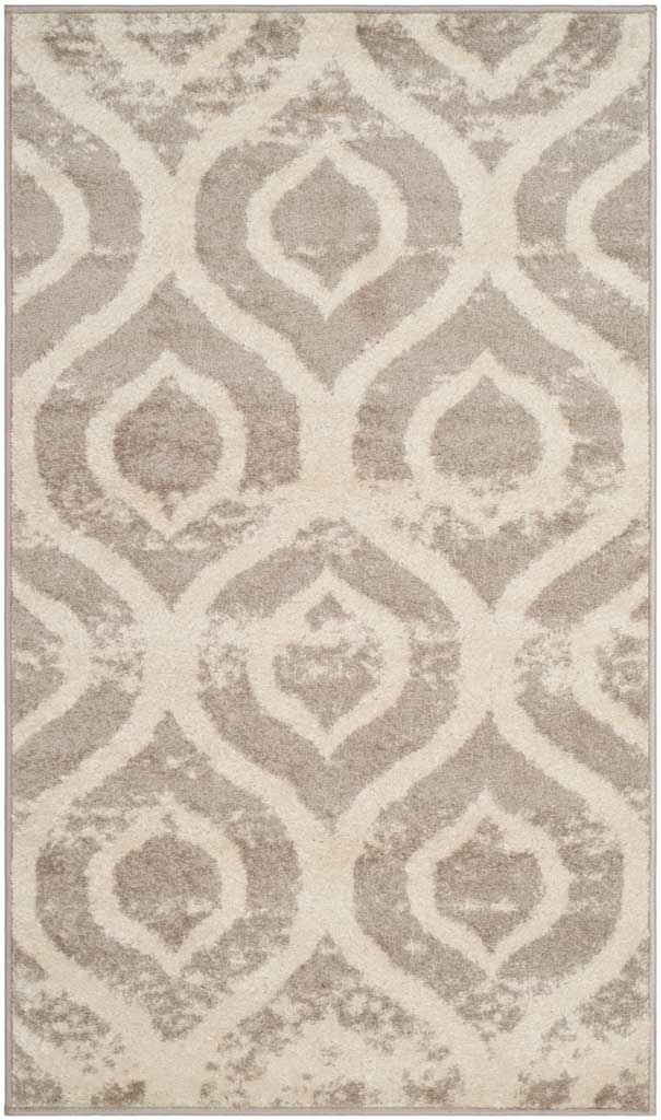 Oversized mauve ogee motifs create a striking, weathered pattern on this ivory area rug