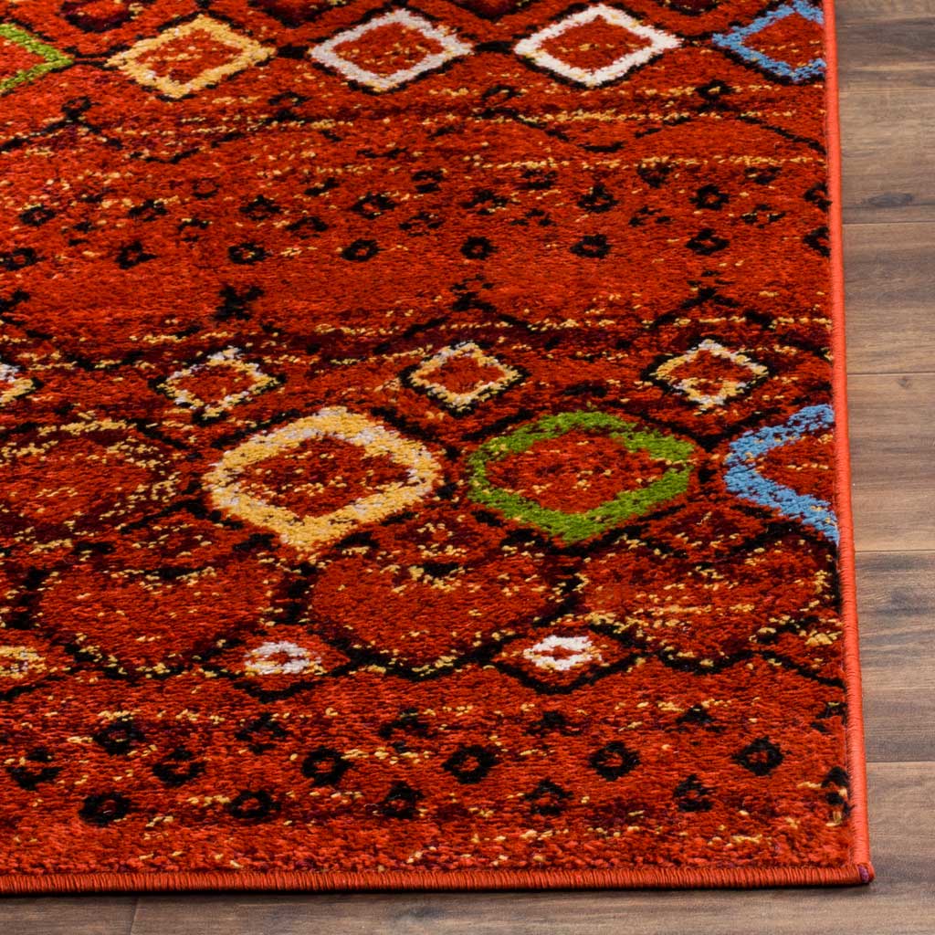 Rich terracotta pile and vivid diamond motifs meet a neatly bound edge