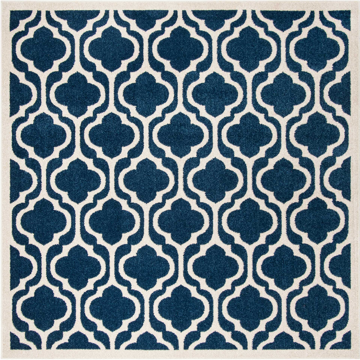 Square rug features bold navy quatrefoils, a beige lattice, and a slim border.