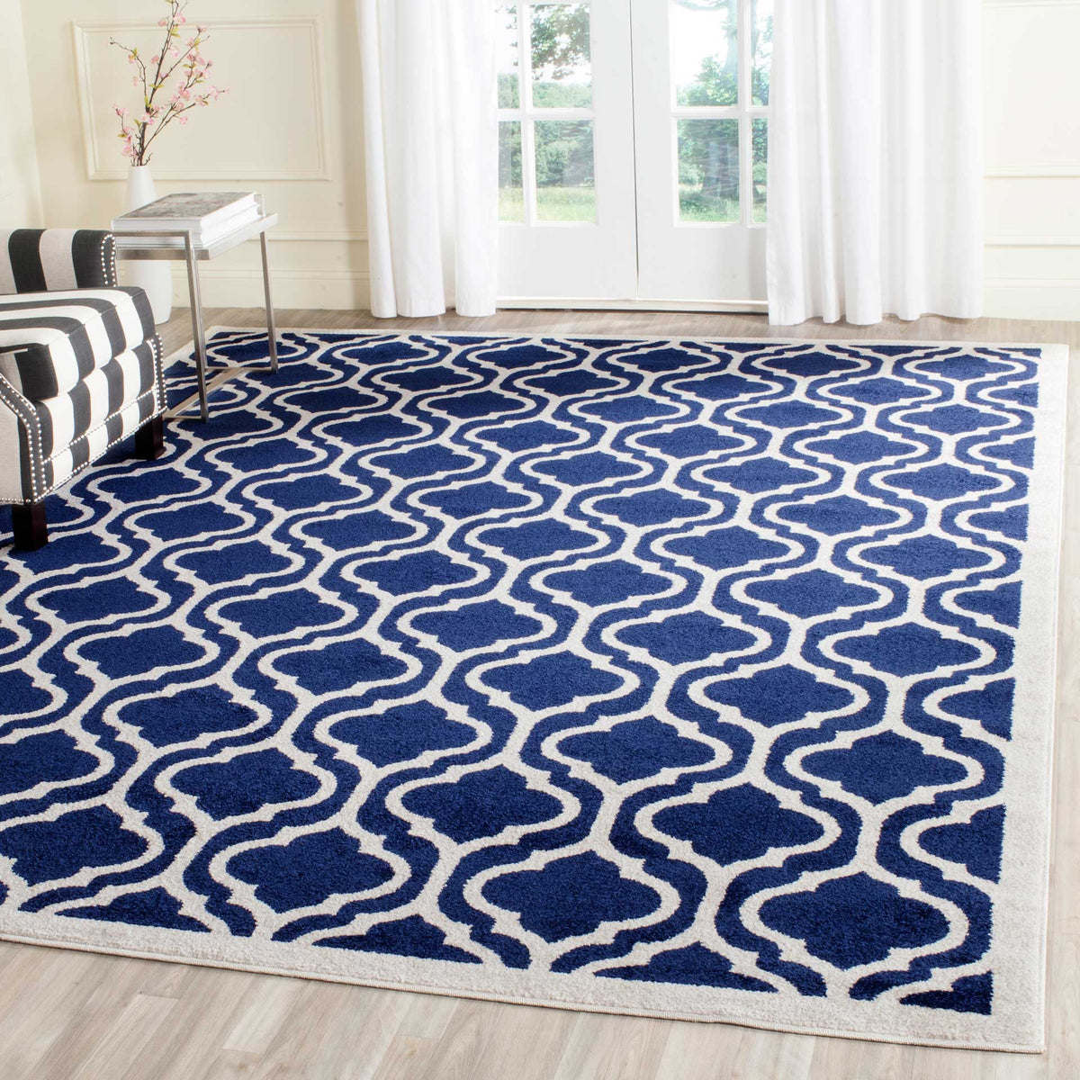 A navy and beige geometric rug anchors a bright living room with its flowing trellis design.