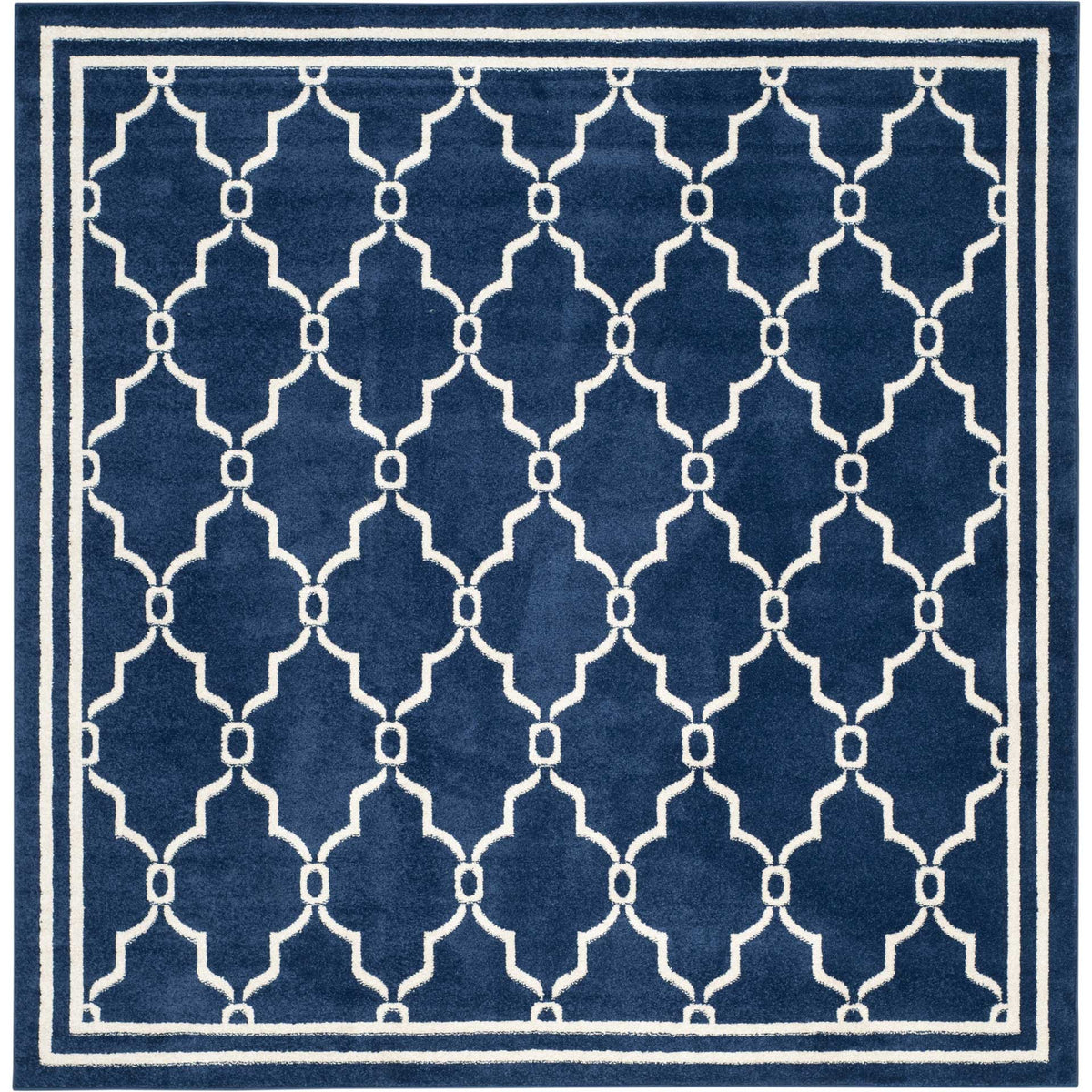 Square navy rug showcases interlocking beige quatrefoils inside a clean double border
