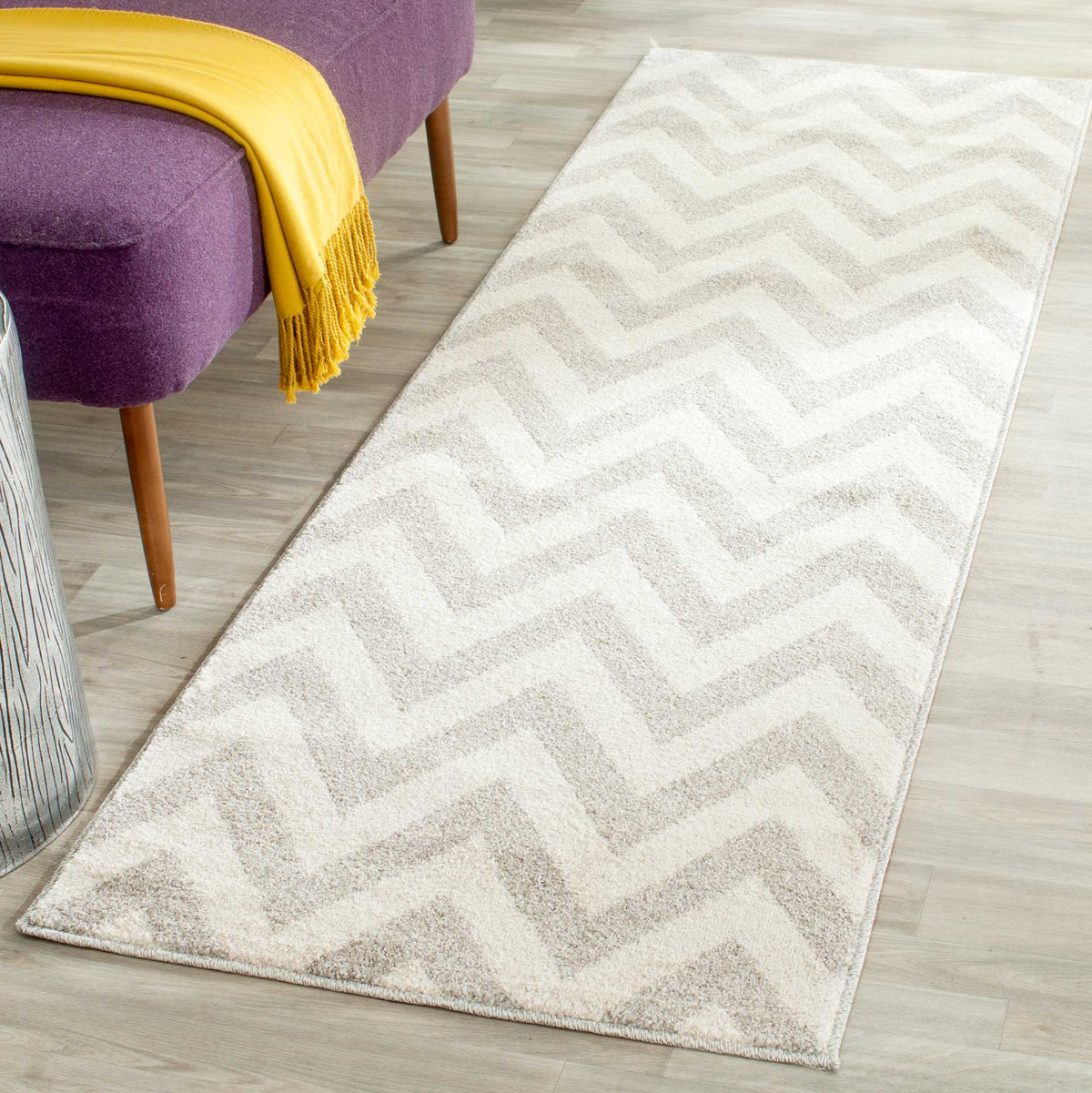 Soft gray zigzags add understated pattern to a light beige runner beside an accent chair.