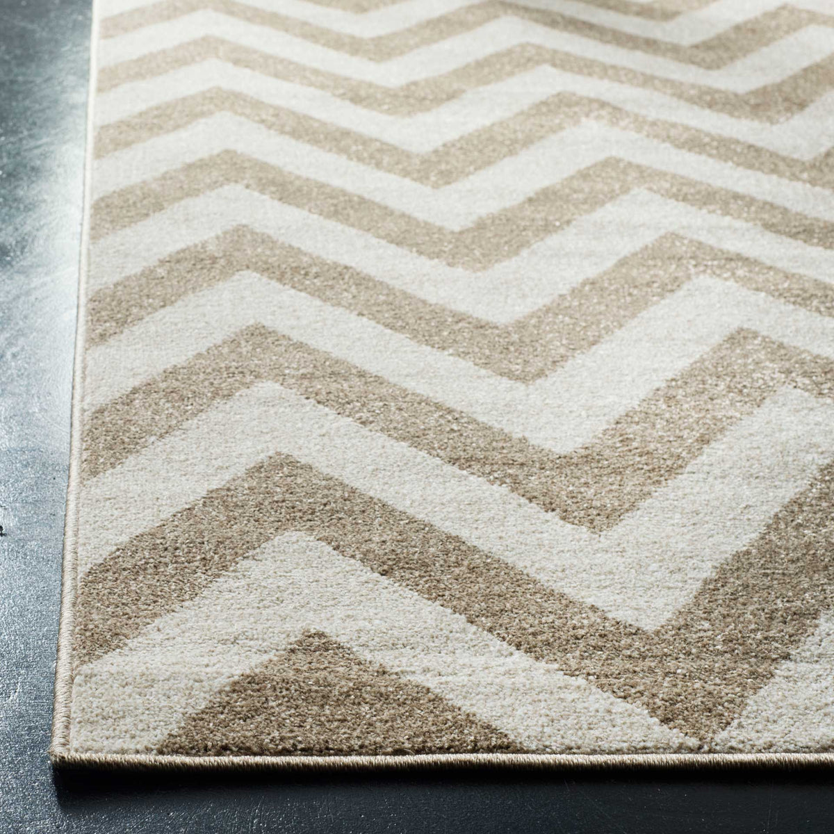 Warm wheat and beige chevrons meet a finished edge, highlighting the rug's soft, even pile.
