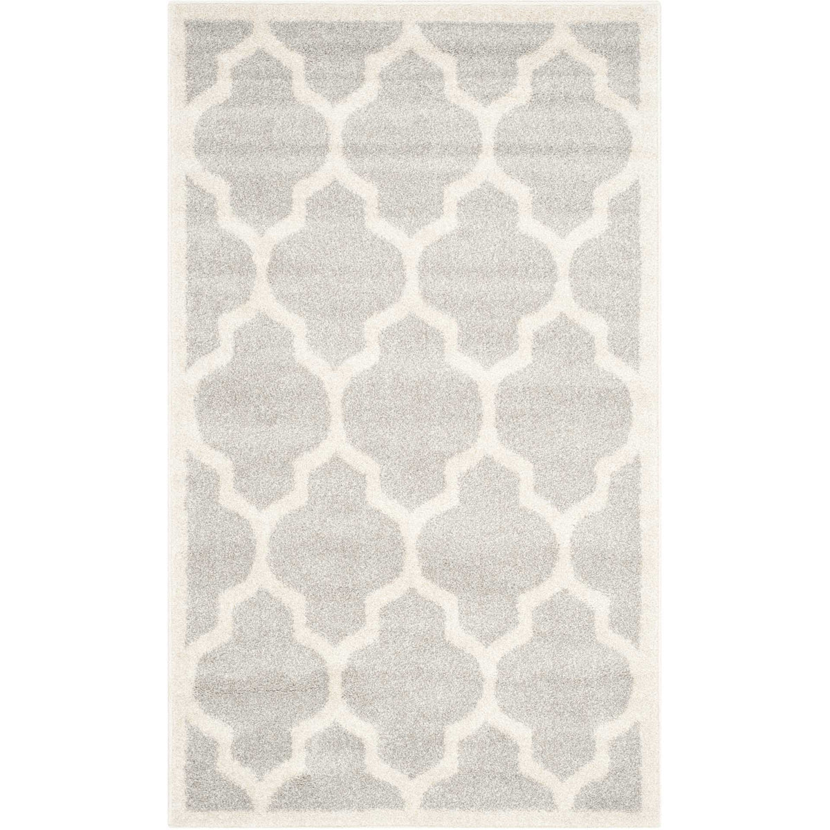 Small light gray rug with a beige quatrefoil motif and subtle light border