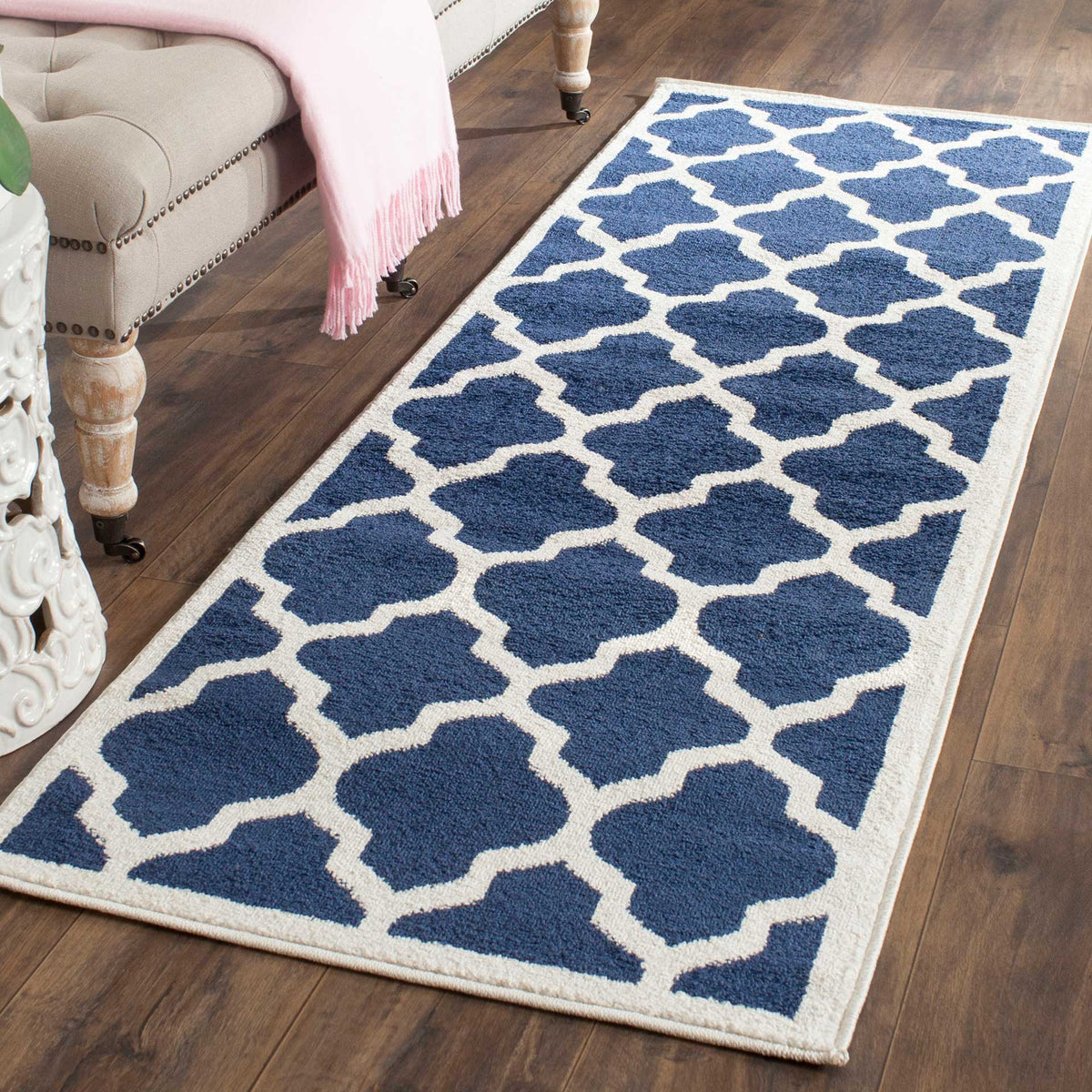 Bold navy motifs stand out against the soft beige lattice of this runner rug