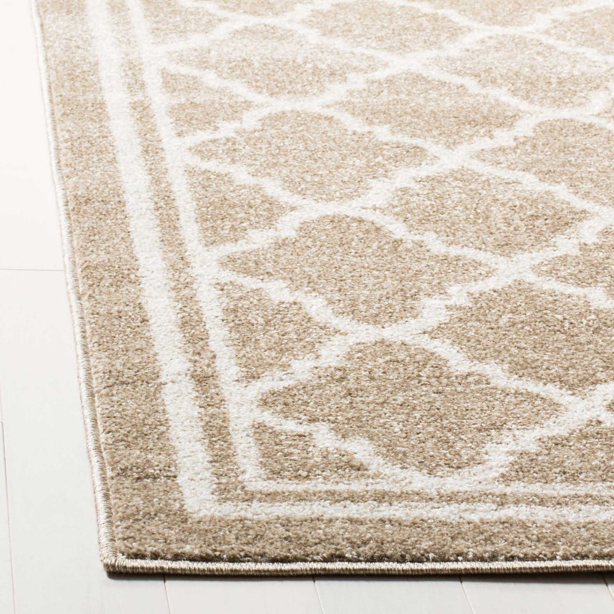 Soft wheat-colored pile meets a beige quatrefoil trellis and neatly bound double border.