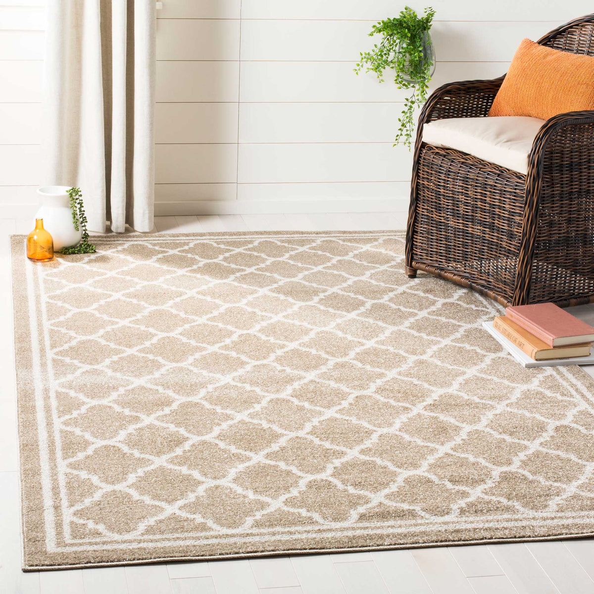 A wheat and beige trellis rug adds a calm patterned base alongside a woven chair.