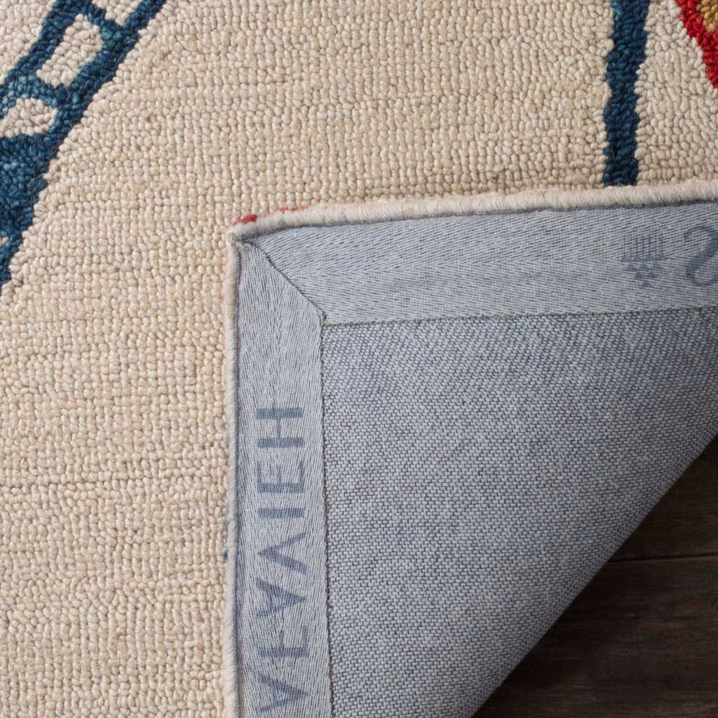 A folded edge reveals woven canvas backing beneath the rug's ivory wool pile and blue detailing.