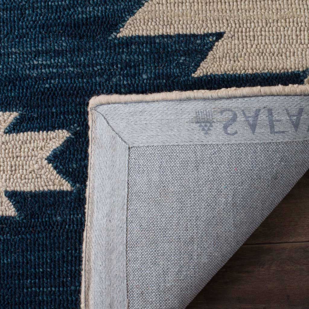 Canvas backing and neatly bound edges complement the ivory and navy wool pile