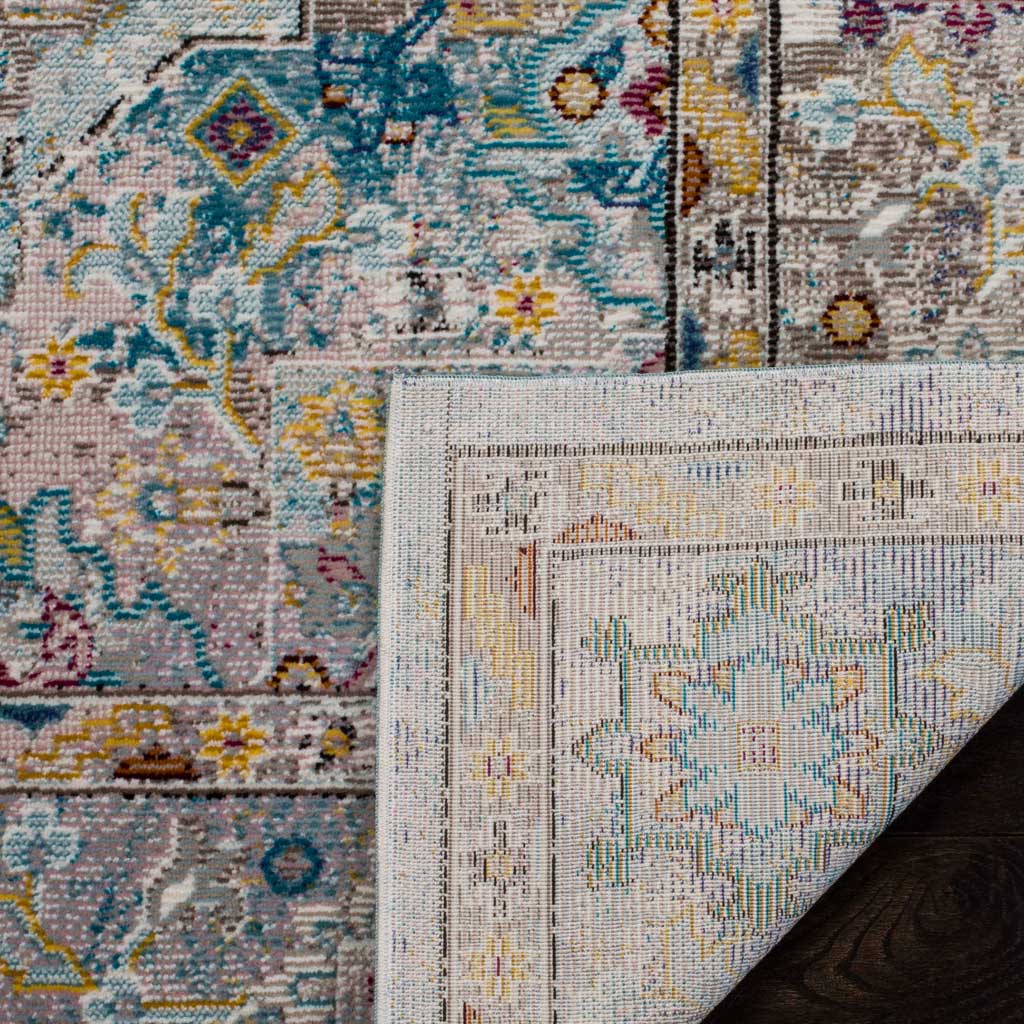 A folded edge reveals the rug's woven backing beneath its colorful floral pattern
