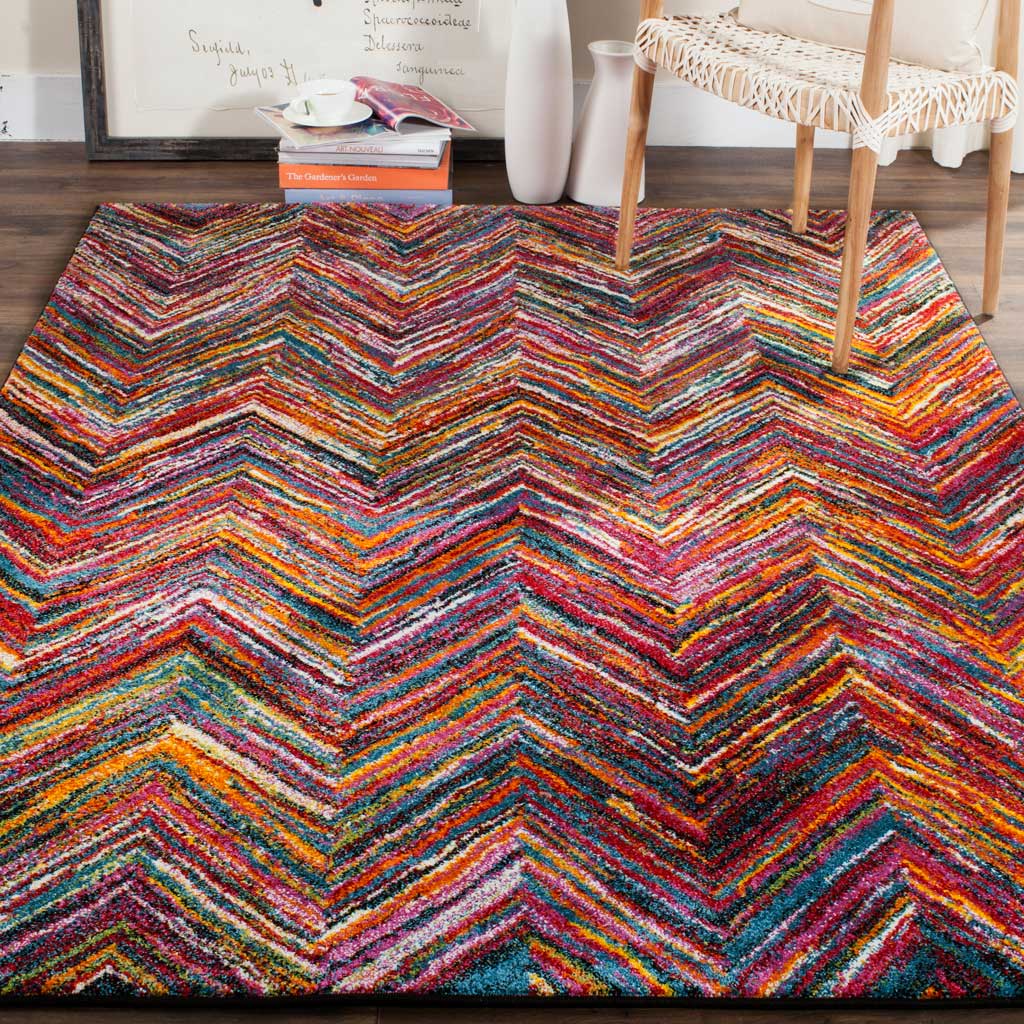 A lively chevron rug brings a vivid mix of pink, orange, and blue to a cozy seating space.
