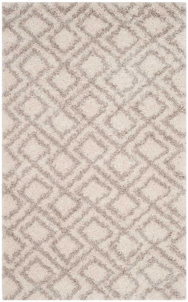 Compact ivory rug is patterned with repeating, interlaced beige diamonds.