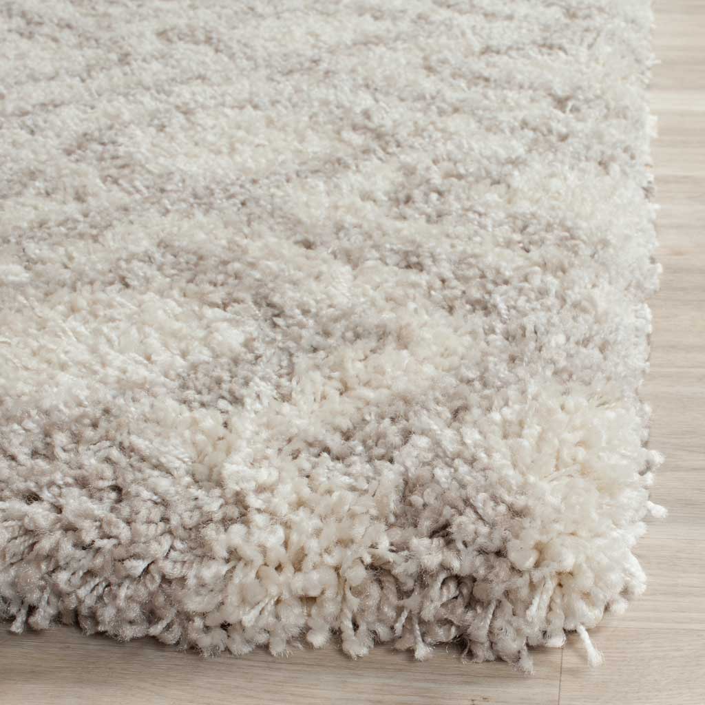 Thick ivory and beige shag fibers gather along a soft, textured rug corner.