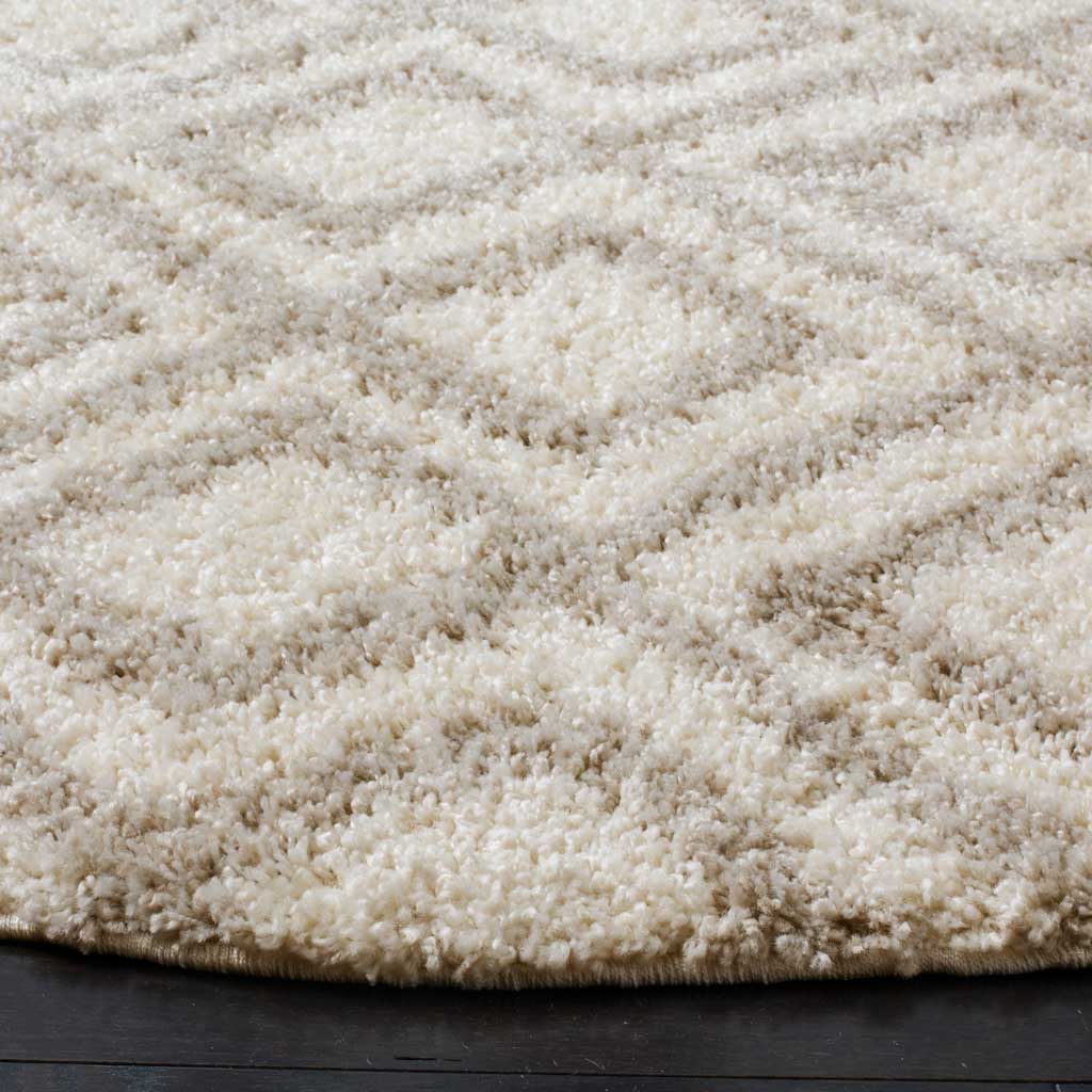 Tufted ivory and beige pile defines a soft diamond pattern and thick rug edge