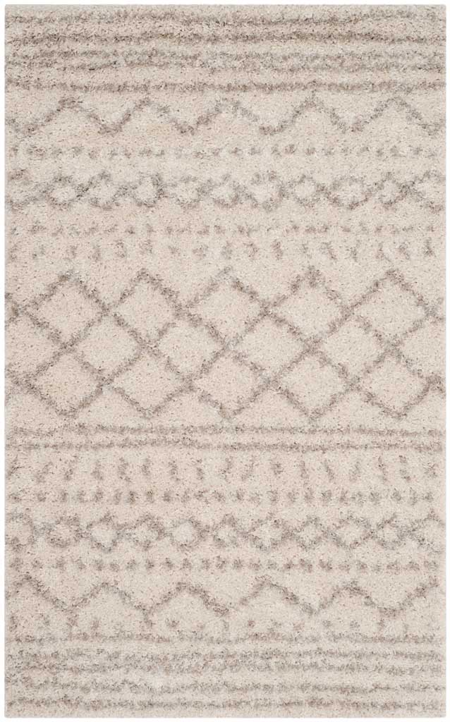 Compact ivory rug pairs subtle beige chevrons, lattice diamonds, and striped borders.