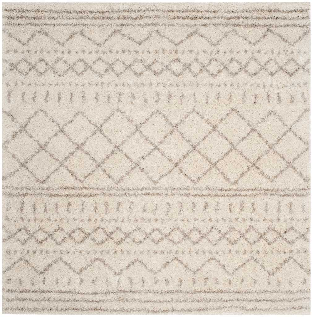 Square ivory rug layers pale beige diamonds and delicate horizontal bands over plush shag.