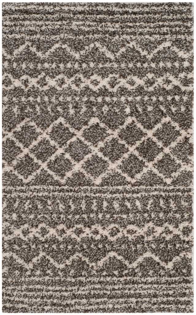 Small brown rug layers ivory geometric bands and diamonds across a plush pile.