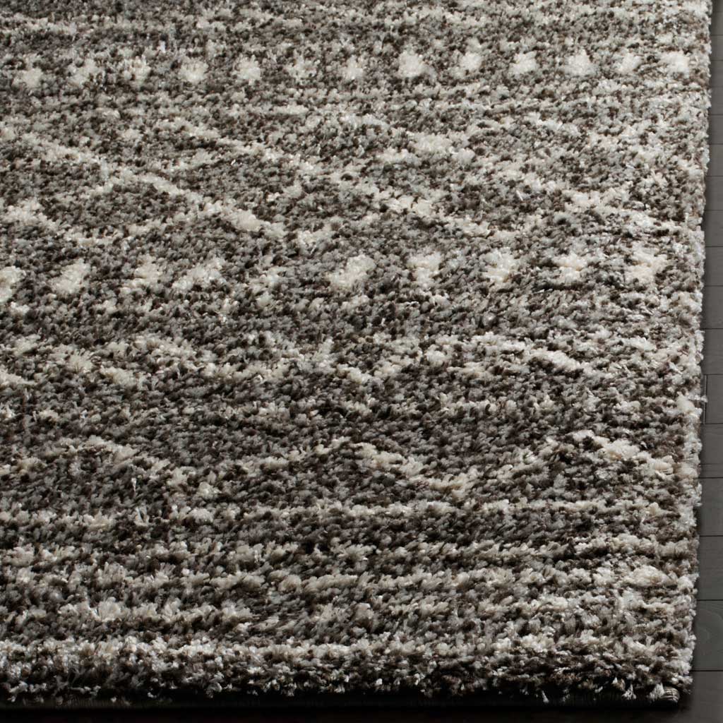 Dense brown and ivory shag brings tactile depth to a patterned, bound rug edge.