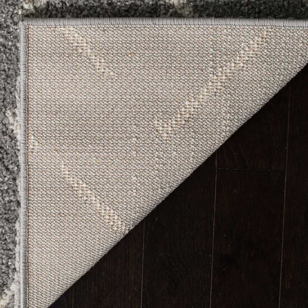 Woven neutral backing and a finished edge provide support beneath soft gray shag.