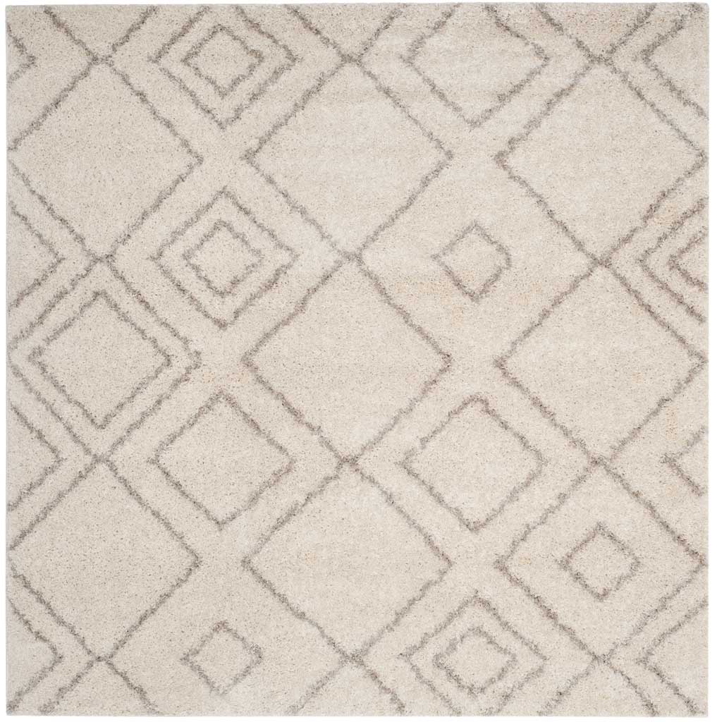 Square ivory rug displays softly sketched beige diamonds across a plush pile.