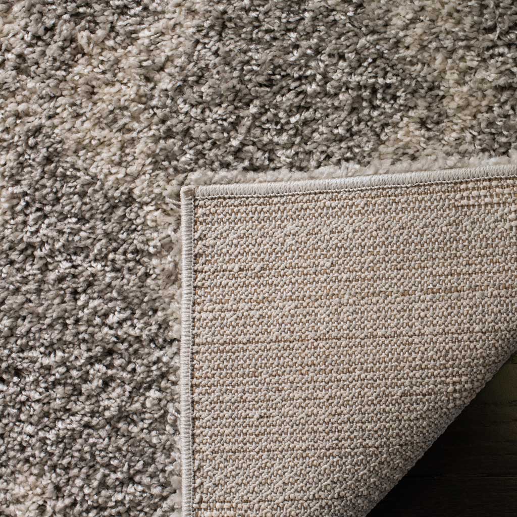 Tightly woven backing and a bound edge lend structure beneath lofty gray shag.