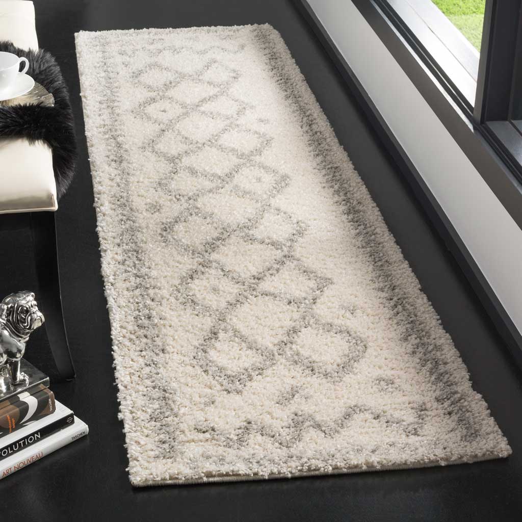 Soft ivory pile highlights a gray diamond chain and delicate borders on this runner.