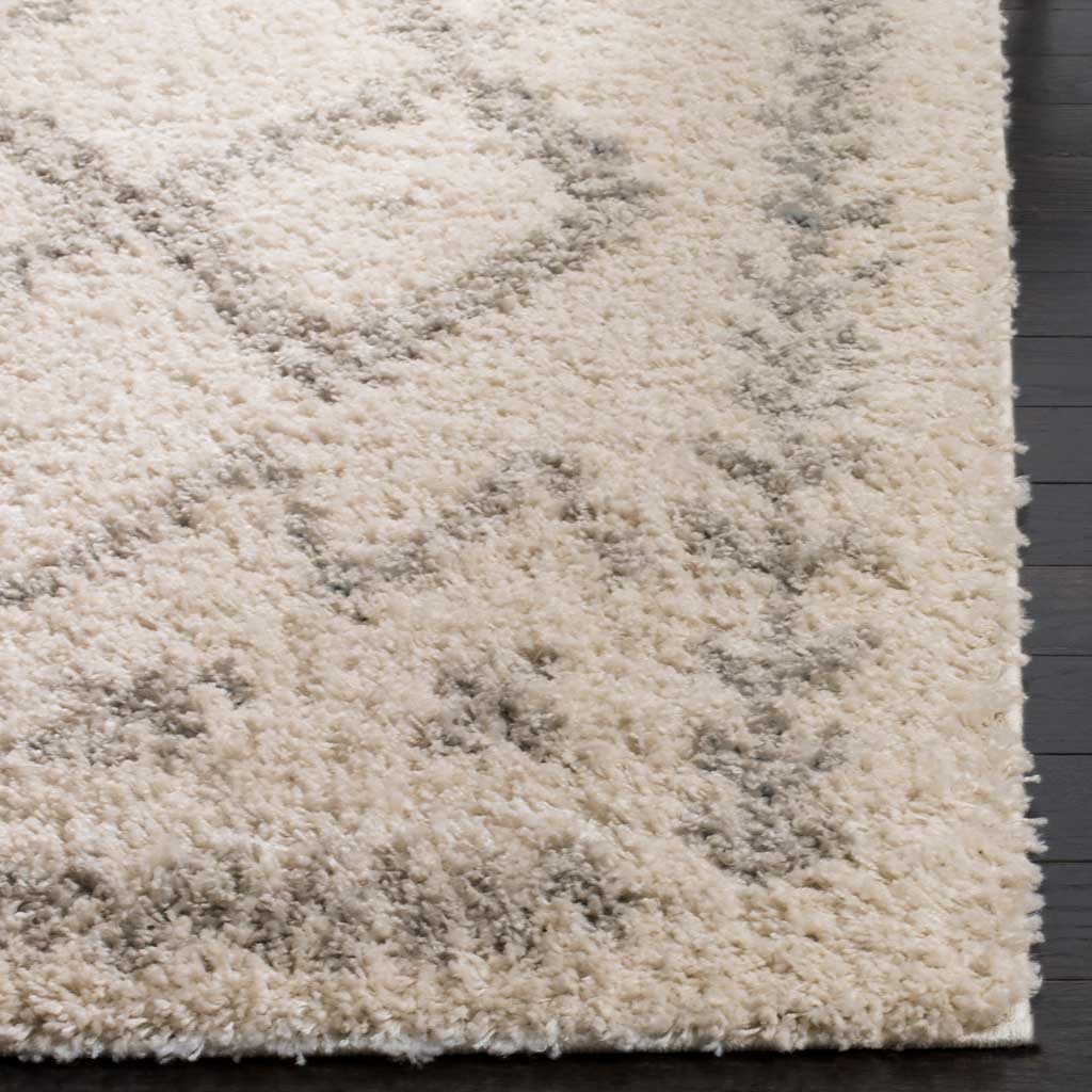 Plush ivory shag and soft gray markings meet at the rug's thick, bound corner.