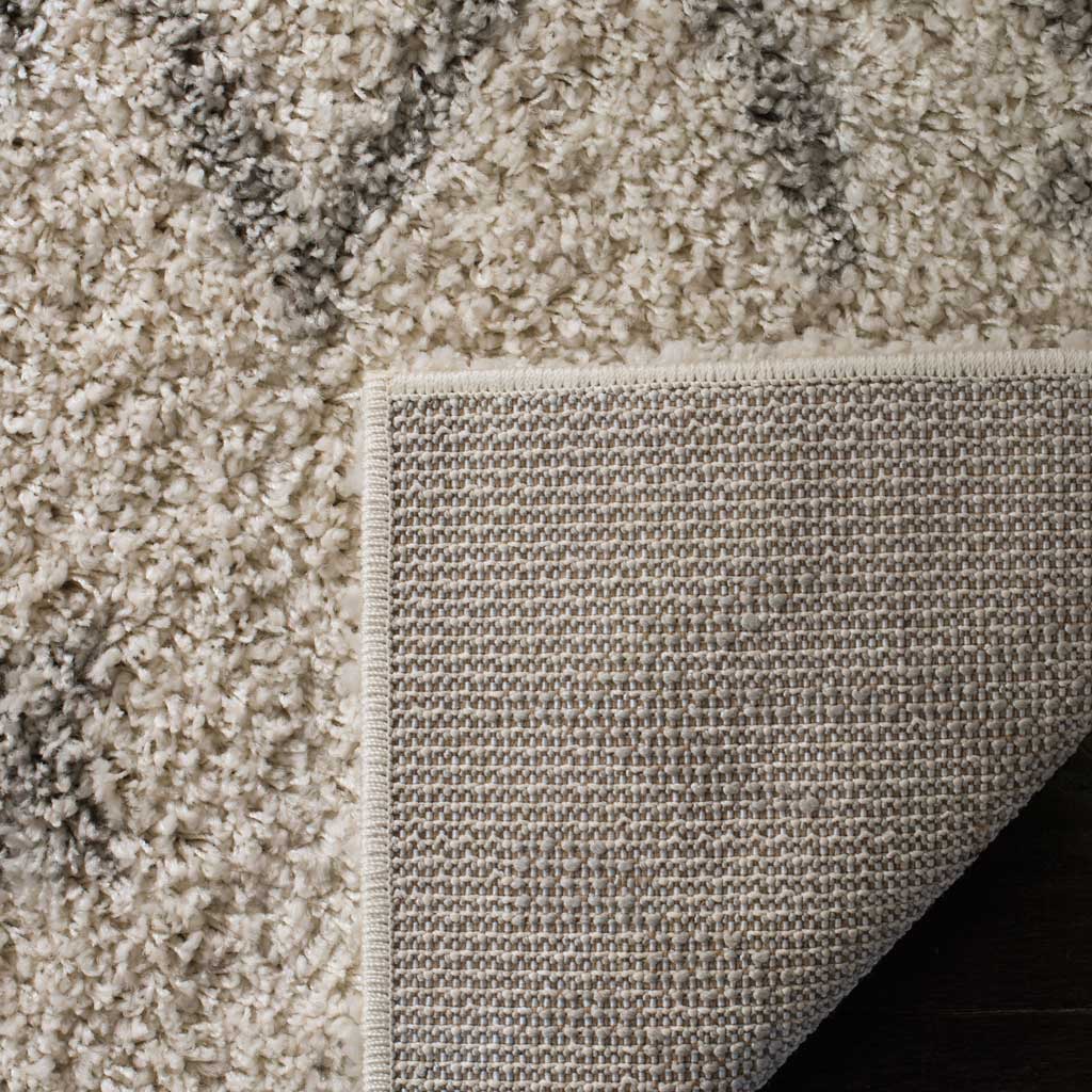 Woven neutral backing and bound edges reinforce the rug's deep ivory shag.