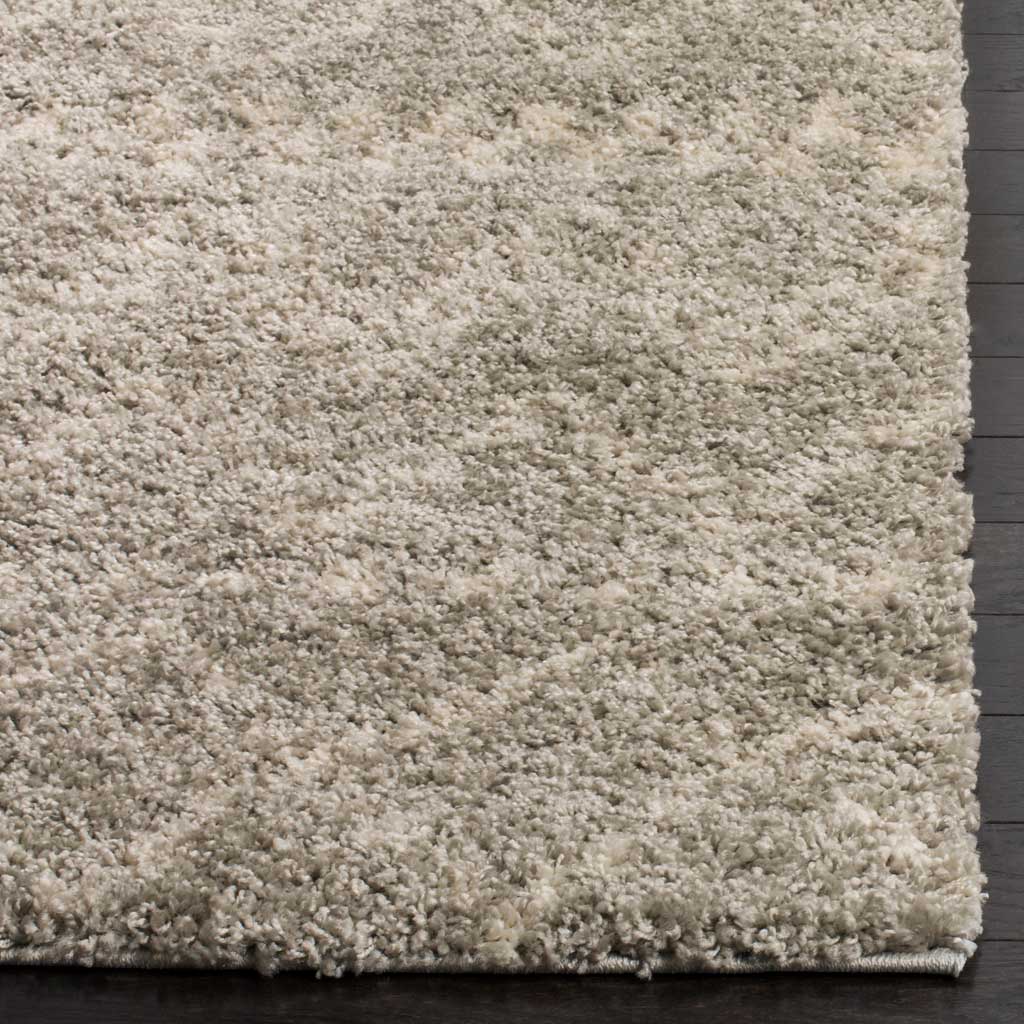 Dense gray and ivory fibers soften the rug's patterned surface and finished edge.