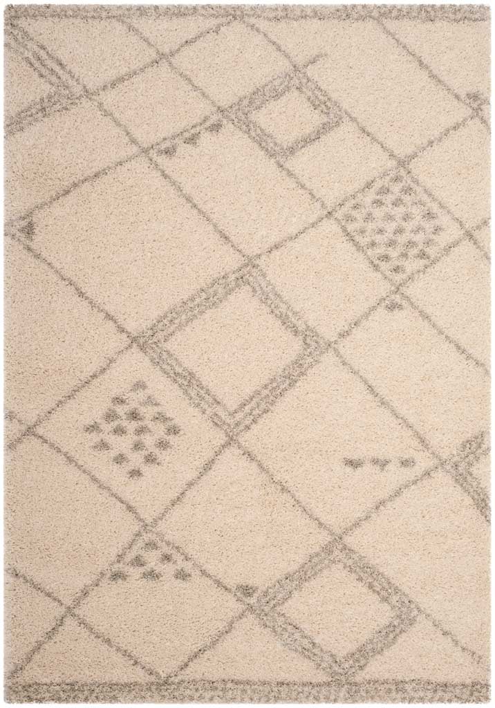 Pale ivory rug pairs intersecting gray lines with framed diamonds and spotted motifs.
