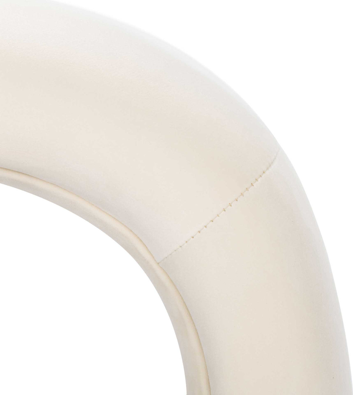 Fine stitching traces the gentle curve of the cream velvet upholstery.
