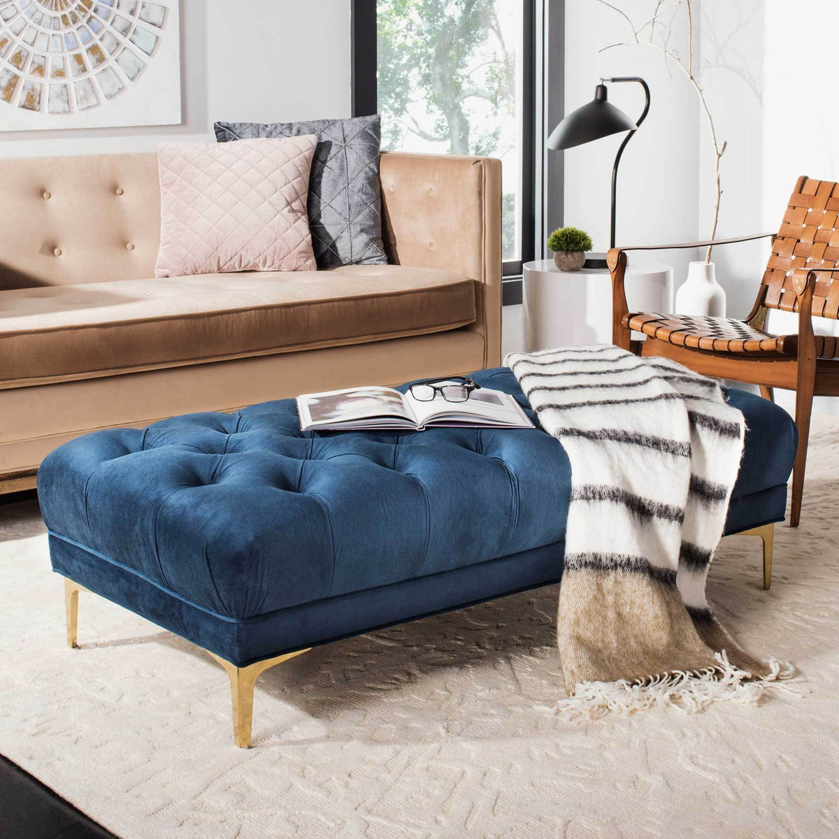 A plush navy velvet bench adds deep tufting and brass-finished legs to a relaxed living area.